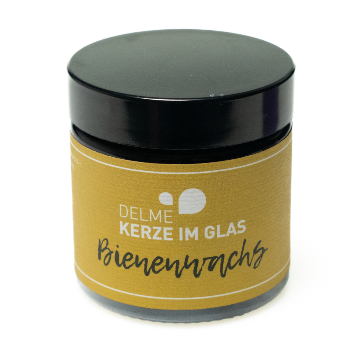 Kleines rundes dunkelbraunes Glas mit schwarzem Deckel und gelbem Etikett mit dezenter schwarzer Aufschrift. Das Wachs der Kerze ist gelb.