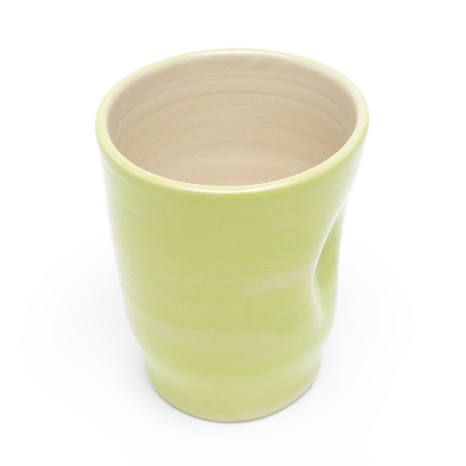 Ein hoher, hellgrüner leicht durchscheinend glasierter gerader Becher, der nach oben hin etwas breiter wird. An der Seite ist eine Daumenmulde für besseren Halt. Das innere des Bechers ist ein naturbelassenes helles Beige.