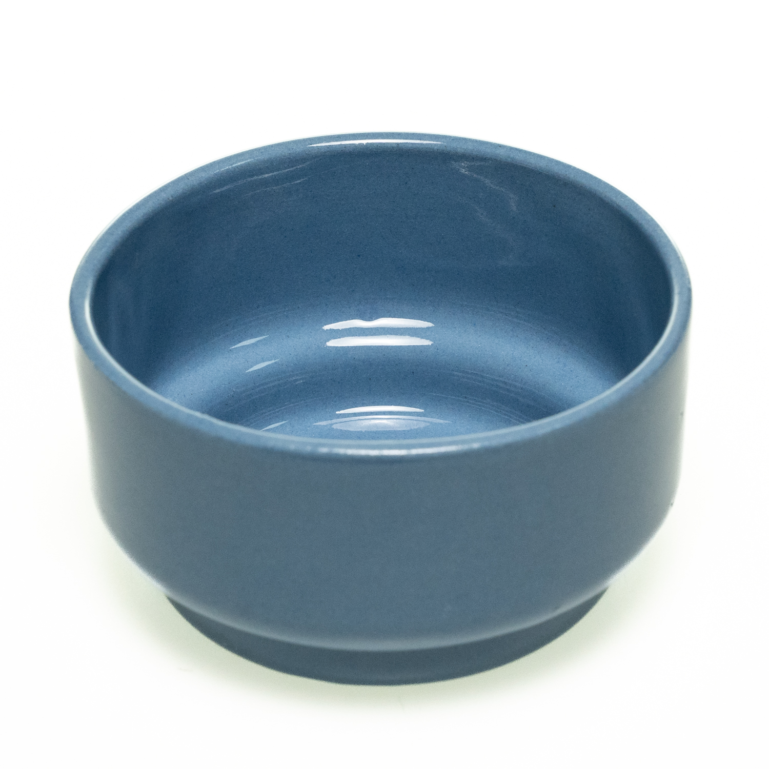 Schlichte, zylindrische Keramikschale in blau mit glatter Oberfläche. Der untere Rand ist leicht zurückgesetzt.