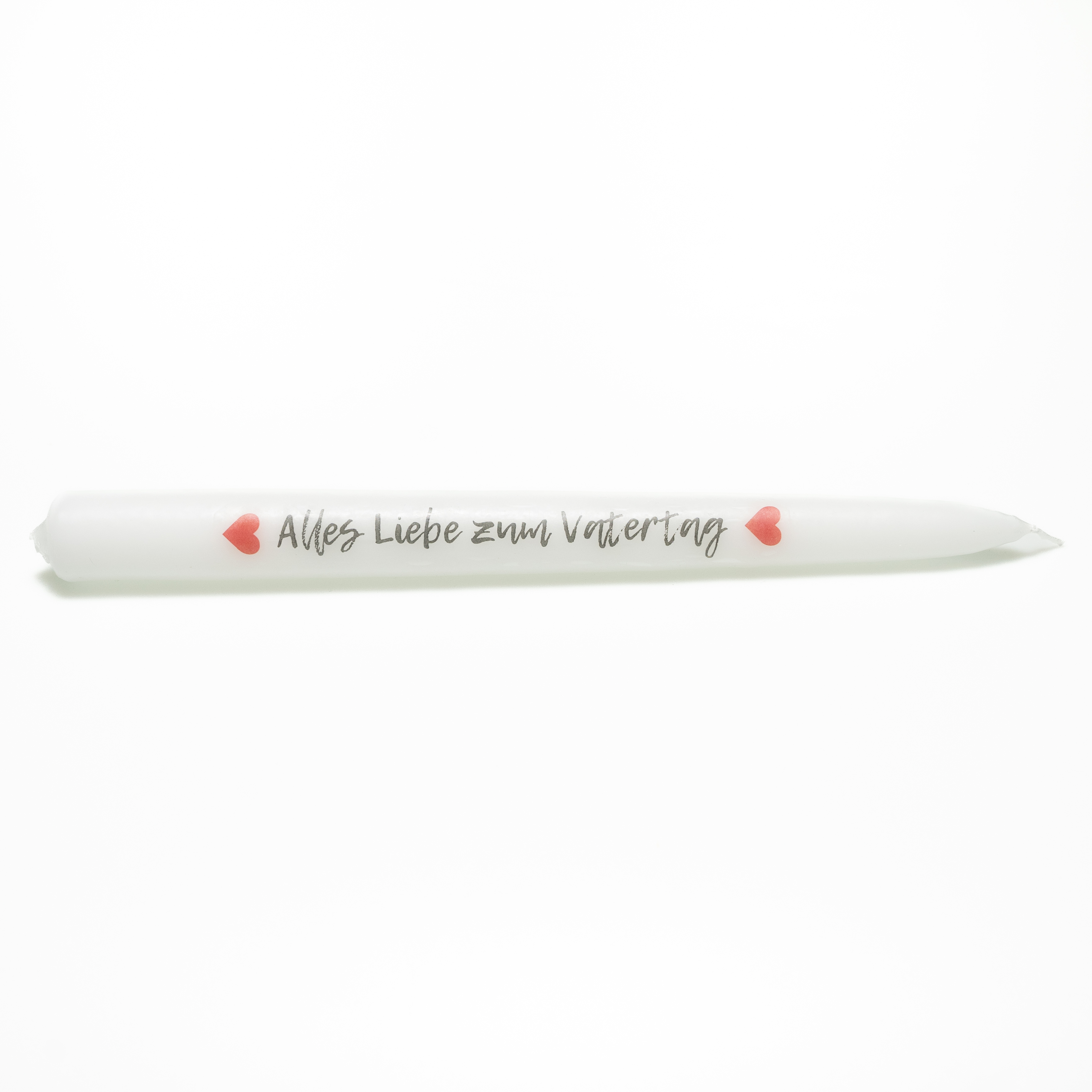 Weiße Tafelkerze mit der Aufschrift „Alles Liebe zum Vatertag“ in schwarzer Handschrift. Der Satz ist von zwei roten Herzen umrahmt.