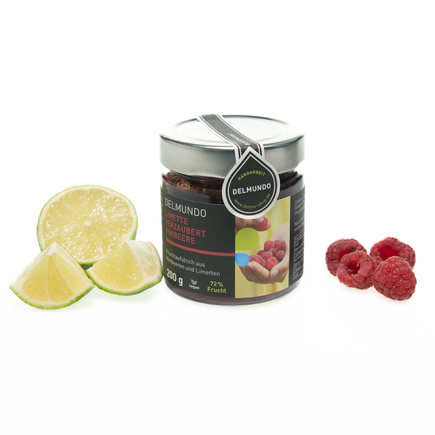 Rundes Glas mit silbernem Deckel, gefüllt mit dunkelrotem Fruchtaufstrich. Daneben liegen eine frische aufgeschnittene Limette und 4 frische Himbeeren.