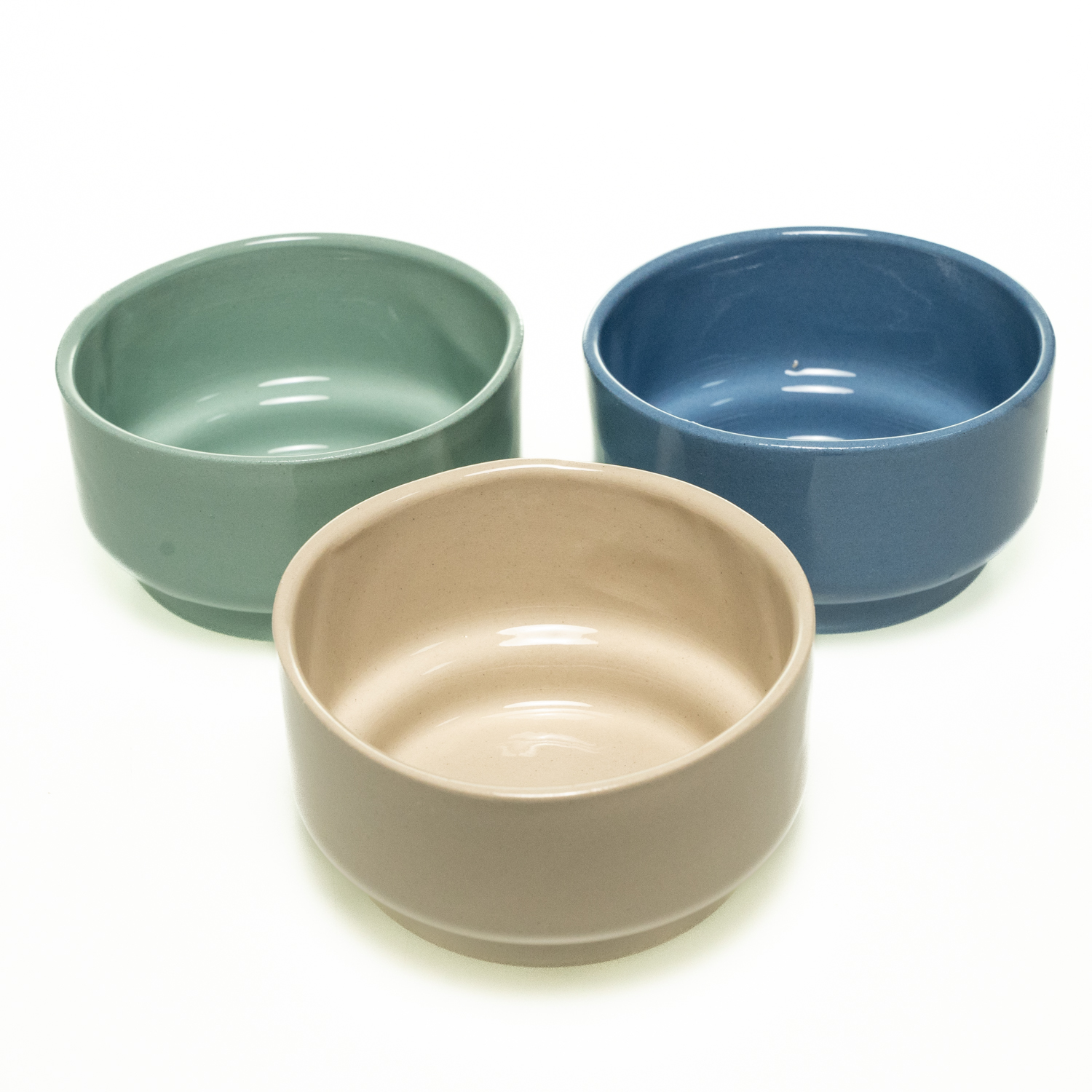 Drei schlichte, zylindrische Keramikschalen in mit glatter Oberfläche in den Farben blau, mintgrün und beige. Der untere Rand ist leicht zurückgesetzt.