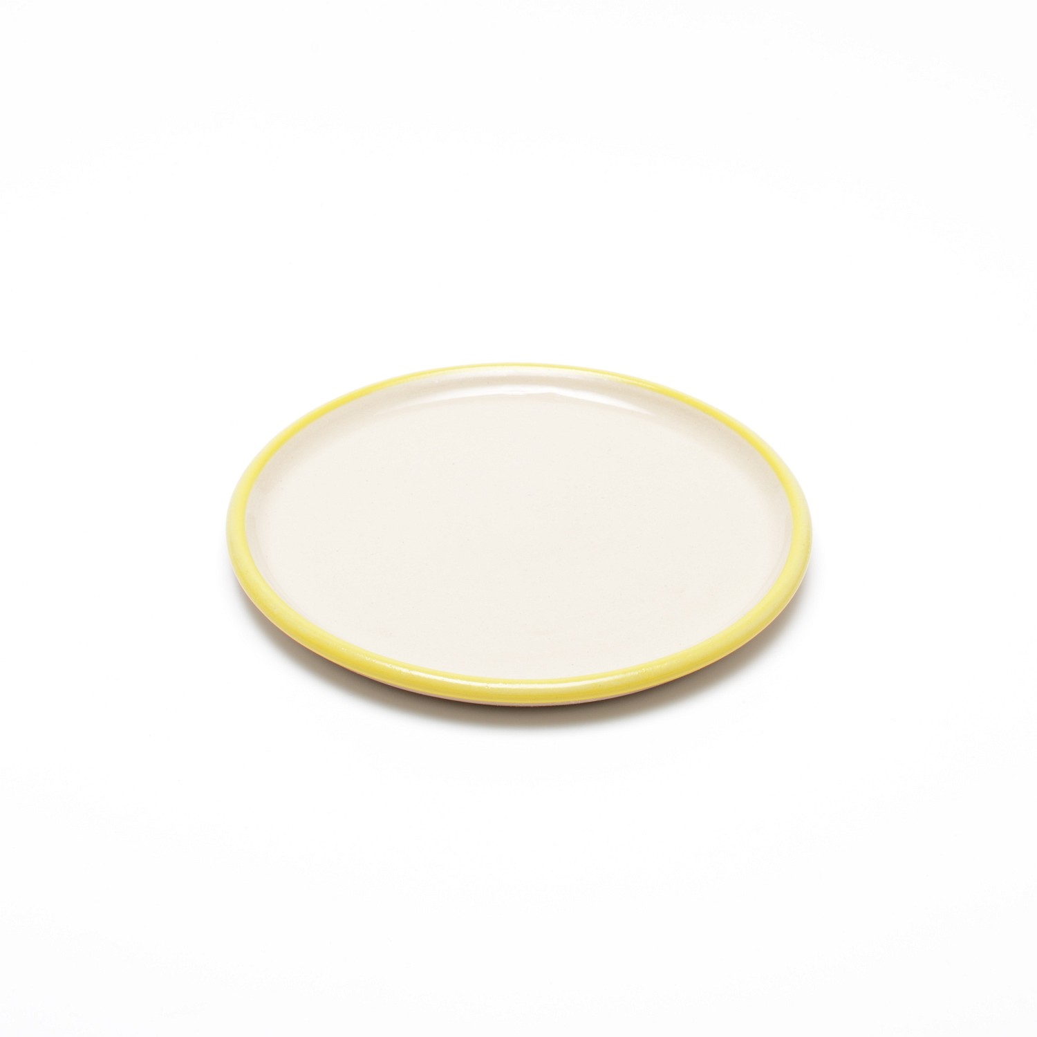 Ein kleiner, runder Teller in einem naturbelassenem hellen Beige, mit einem schmalen gelbem Streifen am Rand.