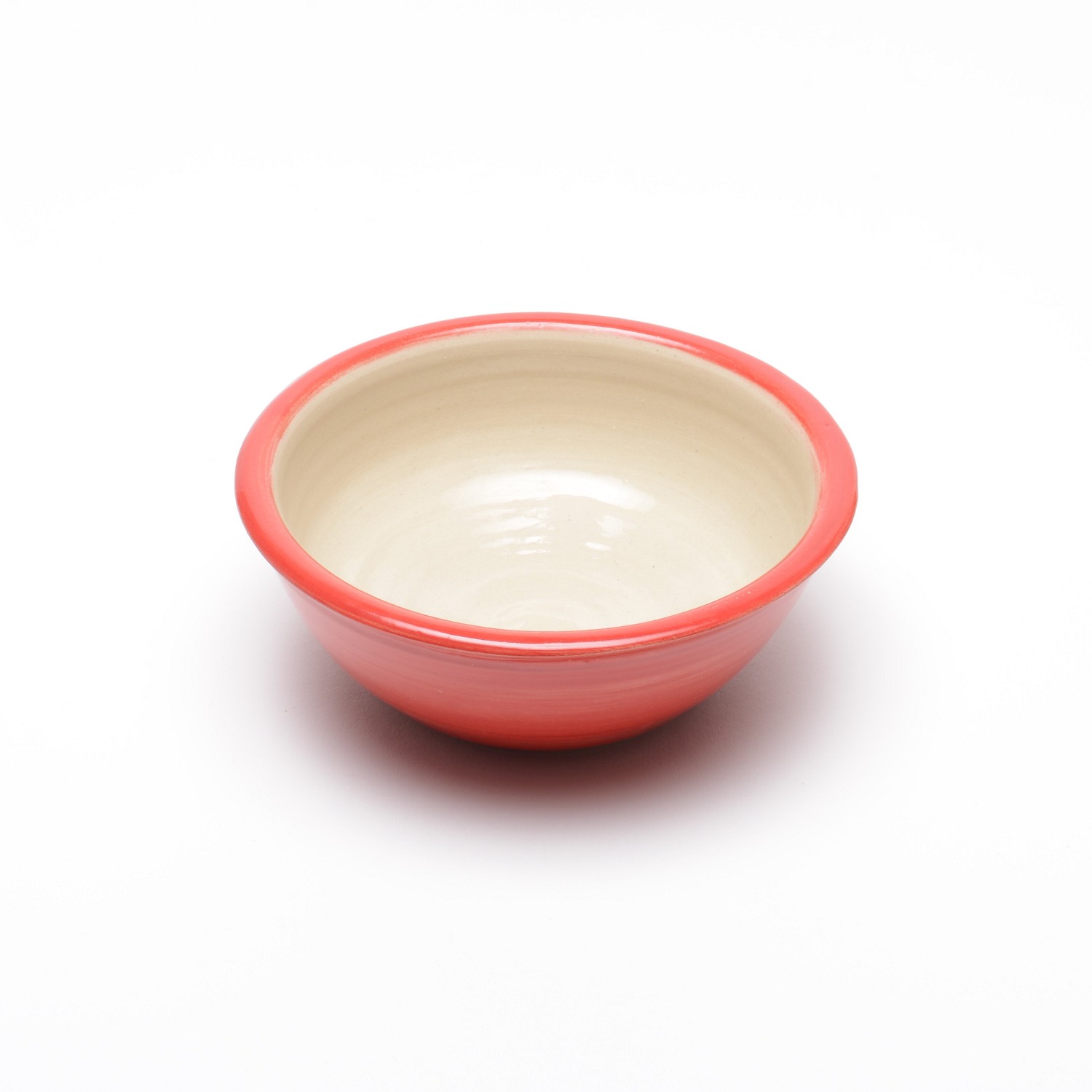 Eine kleine, runde, hellrote, leicht durchscheinend glasierte Schale. Das innere der Schale ist ein naturbelassenes helles Beige.