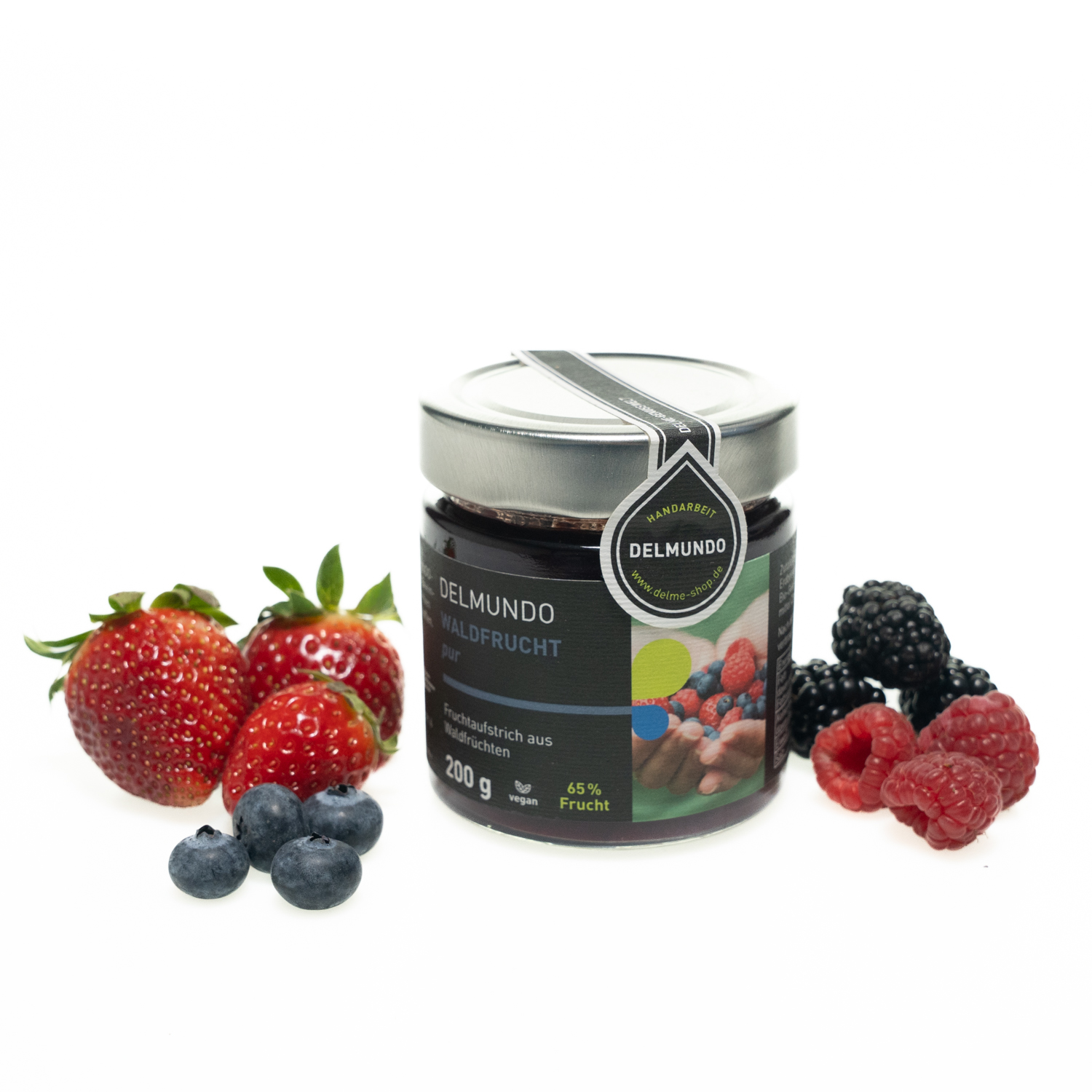 Rundes Glas mit silbernem Deckel, gefüllt mit dunkelviolettem Fruchtaufstrich. Daneben liegen ein paar frische Erdbeeren, Blaubeeren Himbeeren und Brombeeren.