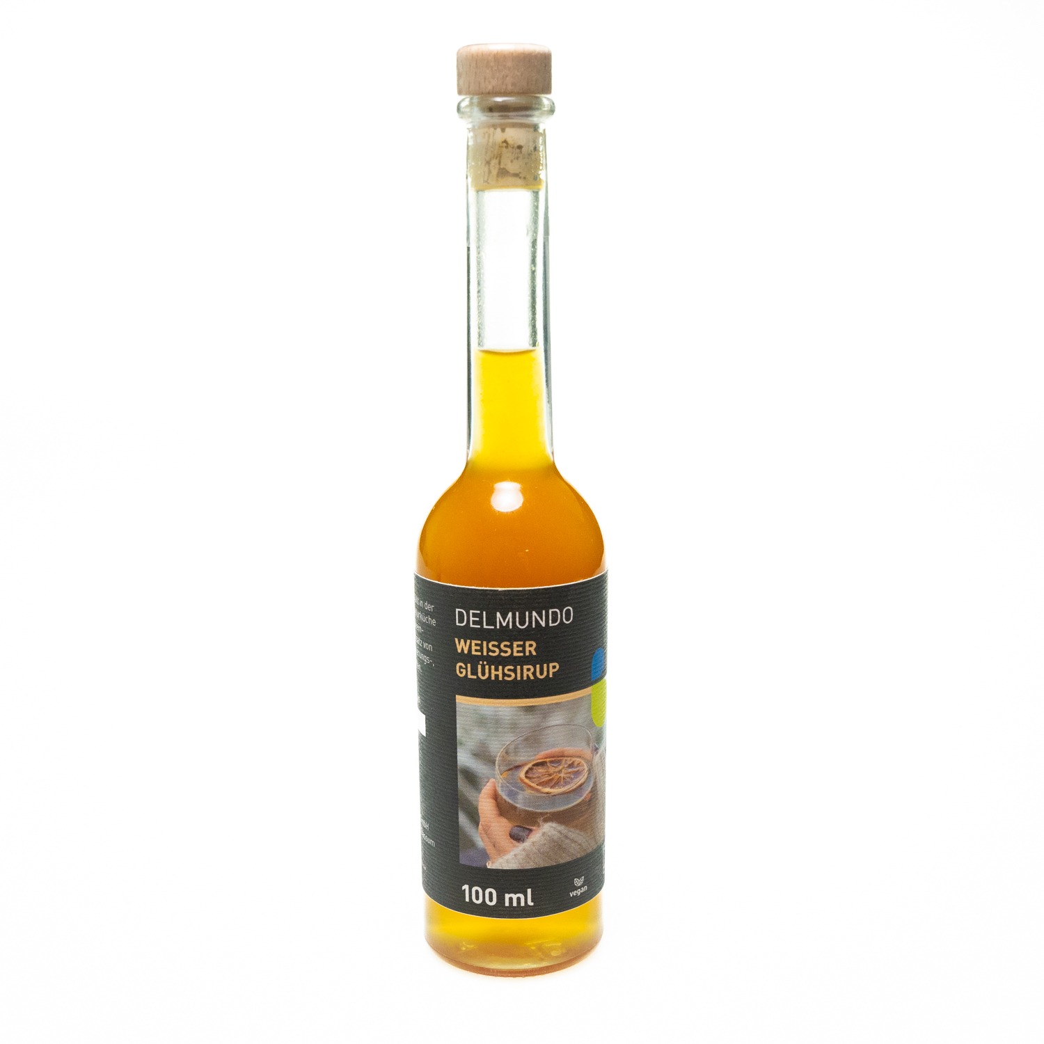 Eine klare Glasflasche mit Bügel-Verschluss gefüllt mit hellegoldenem Glühsirup. Daneben liegen Zimtstangen und Gewürznelken.