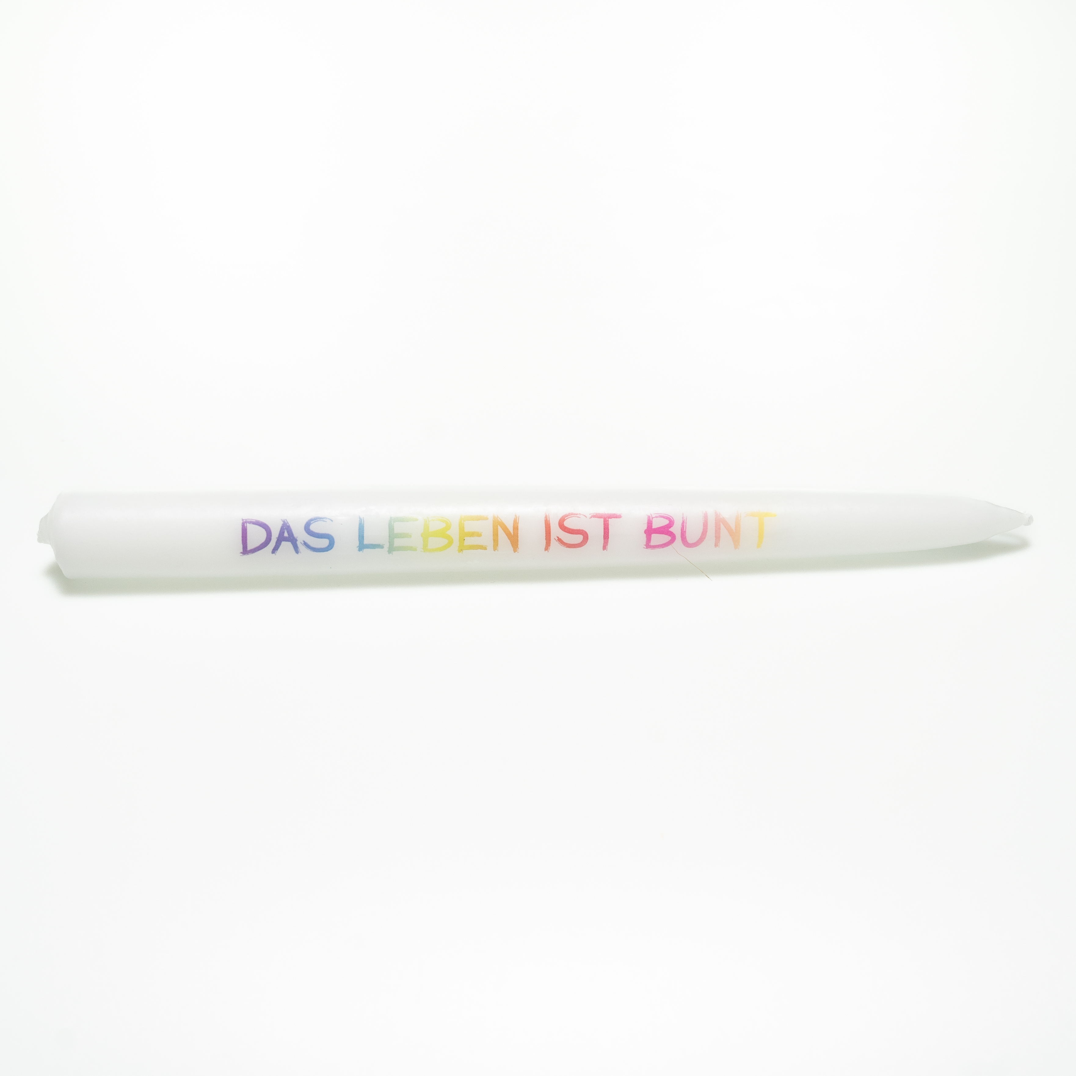 Weiße Tafelkerze mit der Aufschrift „DAS LEBEN IST BUNT“ in Versalien geschrieben mit einem bunten Farbverlauf