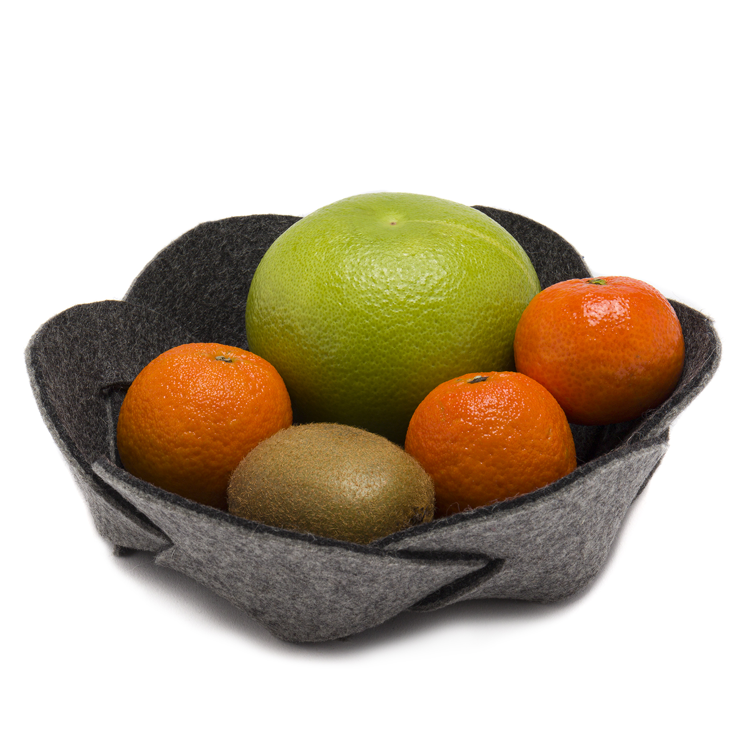 In einer Filzschale liegen drei Clementinen eine Kiwi und eine Pampelmuse