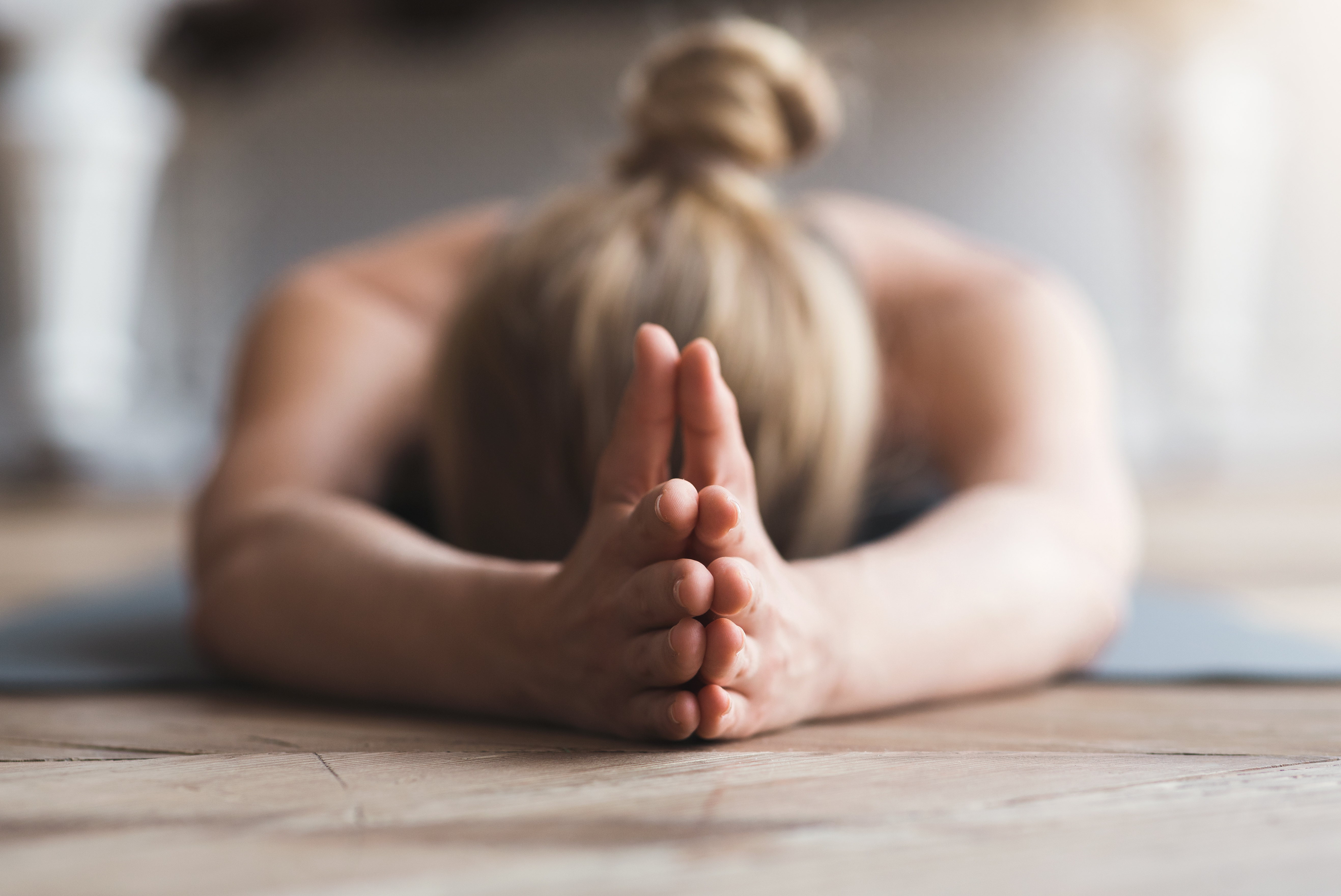 Eine Frau, die in einer Yogaposition auf dem Boden liegt